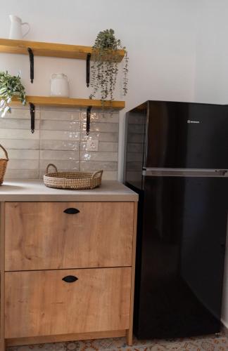 a kitchen with a black refrigerator and a wooden cabinet at La Casa di Varvara e Nikolas in Soroni