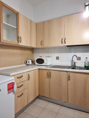 a kitchen with wooden cabinets and a microwave at Rialto House in Venice
