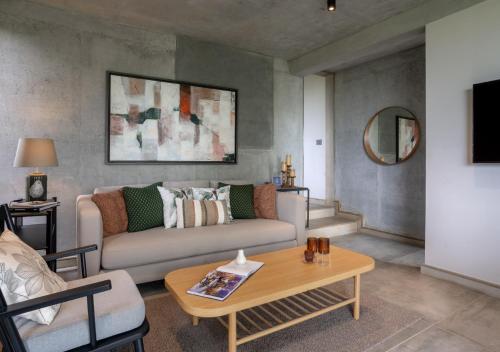 a living room with a couch and a table at LohonoStays Villa Amani 8A in Coonoor