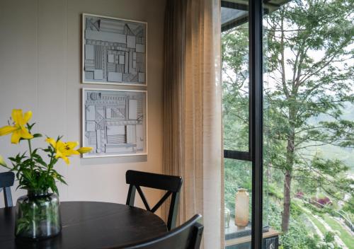 a dining room with a table and a window at LohonoStays Villa Amani 8A in Coonoor