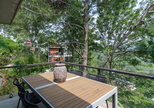 a vase sitting on a wooden table on a balcony at LohonoStays Villa Amani 8A in Coonoor