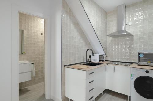 eine weiße Küche mit weißen Schränken und einer Spüle in der Unterkunft Apartamentos Habana 3 in Barbate