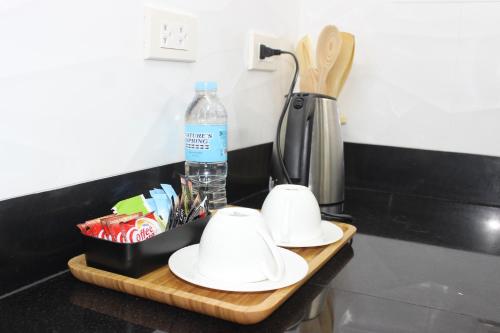 a bottle of water and two white dishes on a counter at Deluxe room with king bed and Balcony at Kandi Palace in Angeles