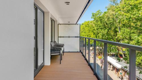 a balcony with chairs and a view of trees at Apartamenty Helski Brzeg in Hel