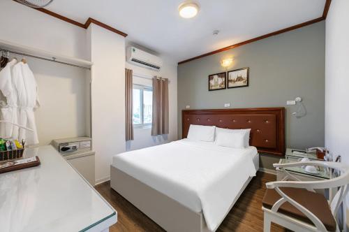 a bedroom with a white bed and a chair at A25 Hotel - 185-187 Lò Đúc in Hanoi