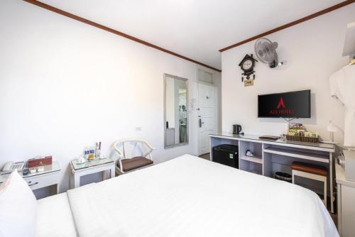a bedroom with a bed and a desk with a tv at A25 Hotel - 185-187 Lò Đúc in Hanoi