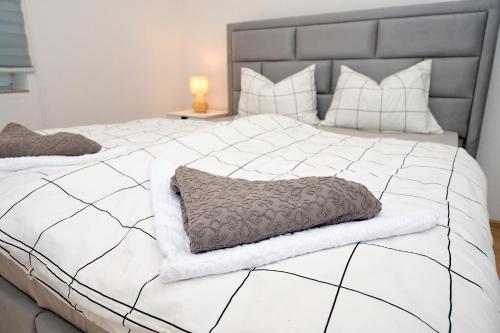 a large white bed with a gray and white comforter at Apartman Astral in Jajce