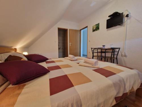 a bedroom with a large bed with a tv on the wall at House Luketić in Rastovača