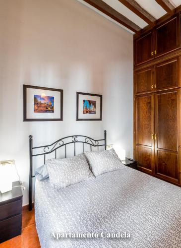 a bedroom with a bed and a wooden cabinet at Apartamentos Candela Alora in Alora