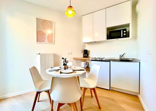 une cuisine et une salle à manger avec une table et des chaises dans l'établissement Jerickais - Studio Bezons 3 personnes, à Bezons