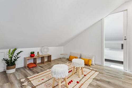 a white living room with two white stools at Villa Camelia by Homie in Santo António