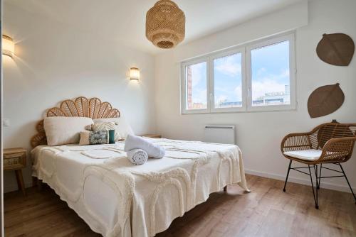 - une chambre dotée d'un grand lit avec des draps blancs et de 2 fenêtres dans l'établissement Proche Lille - T3 Confort - Terrasse, à Mons-en-Baroeul