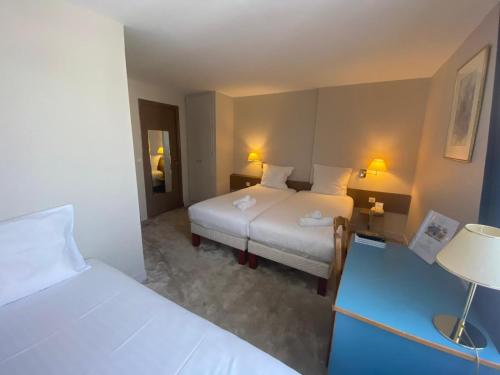 Postel nebo postele na pokoji v ubytování HÔTEL PARIS VÉSINET- Logis Hôtel Restaurant