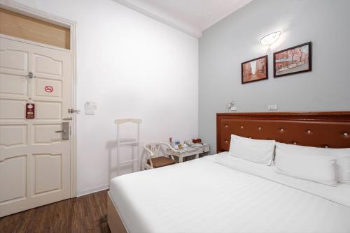 a bedroom with a bed and a door and a table at A25 Hotel - 185-187 Lò Đúc in Hanoi