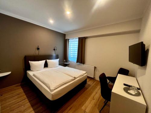ein Schlafzimmer mit einem Bett, einem Schreibtisch und einem Tisch in der Unterkunft Gutshof Havelland in Ketzin