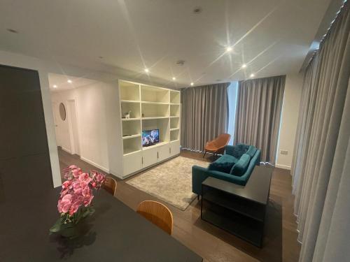 a living room with a couch and a table with flowers at Busco Properties in London