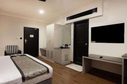 a bedroom with a bed and a flat screen tv at The Budhil Park in Visakhapatnam