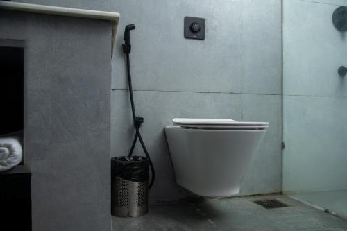 a bathroom with a toilet and a trash can at The Budhil Park in Visakhapatnam