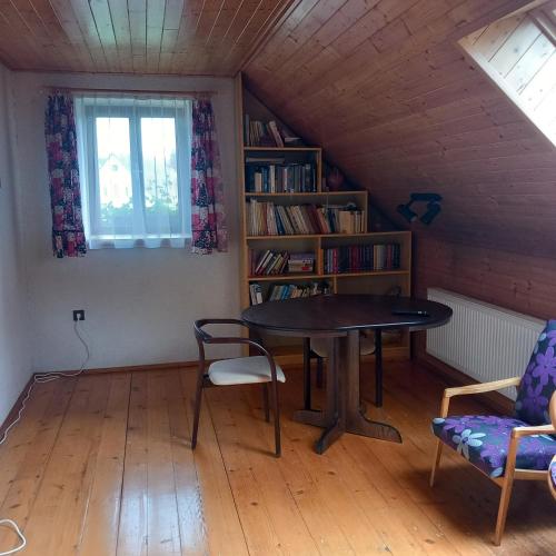 un comedor con una mesa y un estante de libros en U tří jasanů, en Luže