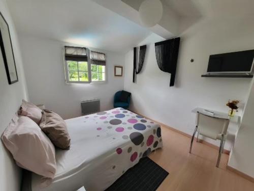 a small bedroom with a bed and a table at Maison ruisseau l'eau blanche in Léognan