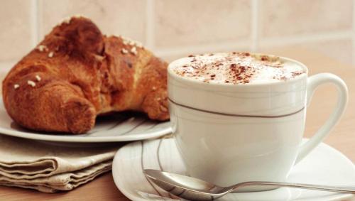 a cup of coffee and a pastry on a table at La Perla Del Tirreno in Tropea