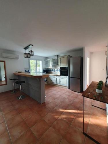 Il comprend une cuisine équipée d'appareils en acier inoxydable et du carrelage. dans l'établissement Maison proche forêt et Bassin d'Arcachon, à Saint-Jean-dʼIllac