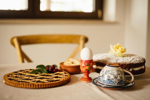 a table topped with cakes and an egg and a candle at Fattoria del Borgo in Sabina in Rieti