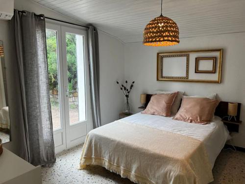 une chambre avec un lit et une grande fenêtre dans l'établissement A SUARELLA - Villa climatisée - 4 chambres - piscine chauffée, à Sainte-Lucie de Porto-Vecchio