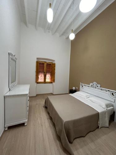 a bedroom with a bed and a dresser and a television at casa di Lorenzino in Carloforte