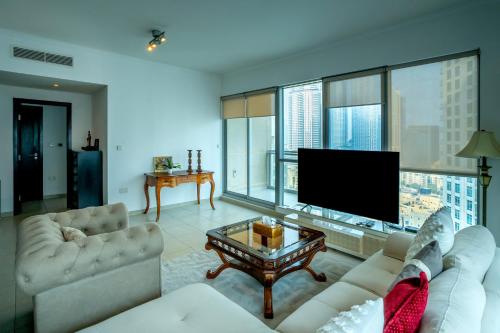 a living room with couches and a flat screen tv at Elegant Apartment Overlooking Dubai Mall Fountain. in Dubai