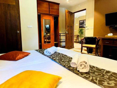 a hotel room with a bed with towels on it at Rivorich Residence Kandy in Kandy