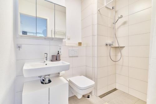 a white bathroom with a sink and a toilet at Ludwiga - Vierstädte Nest in Bietigheim-Bissingen