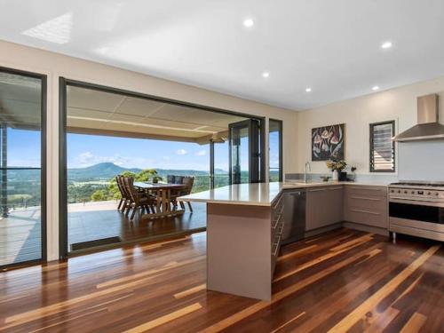 a kitchen with a view of a table and a dining room at Wilderness House in Kulangoor