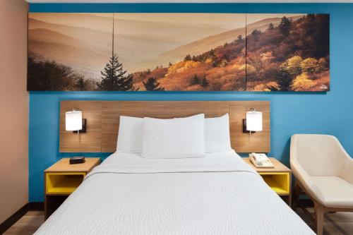 a hotel room with a bed and a painting on the wall at Days Inn by Wyndham Shelby in Shelby