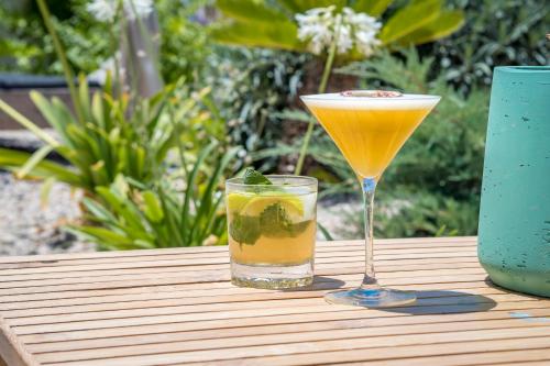 a drink and a glass on a wooden table at Boutique Hotel Los Limoneros in Moraira
