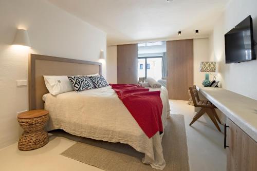 a bedroom with a bed with a red blanket on it at Boutique Hotel Los Limoneros in Moraira