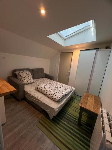 - une chambre avec un lit, un canapé et une lucarne dans l'établissement Joli duplex, à Colombes