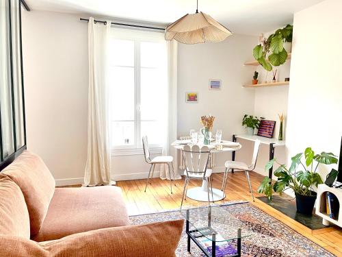 un salon avec un canapé et une table dans l'établissement Jerickais Appartement 3 pièces à Pantin, à Pantin