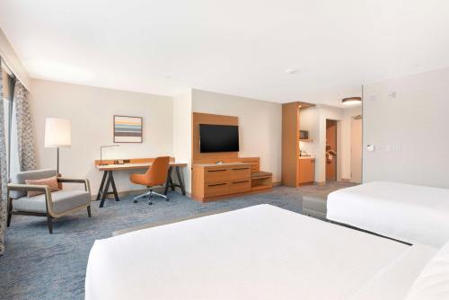a hotel room with two beds and a desk at Hilton Garden Inn LAX - El Segundo in El Segundo