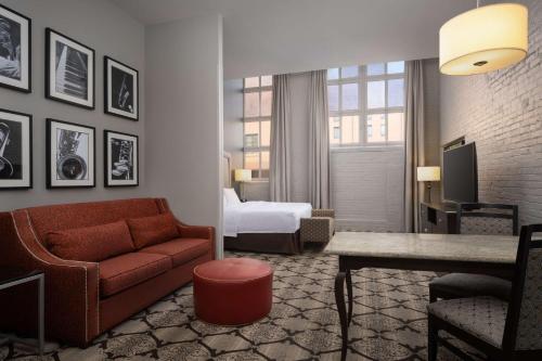 a living room with a couch and a bed at Hampton Inn and Suites New Orleans Convention Center in New Orleans