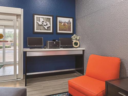a desk with two computers and a chair in a room at La Quinta by Wyndham San Antonio Northwest in San Antonio