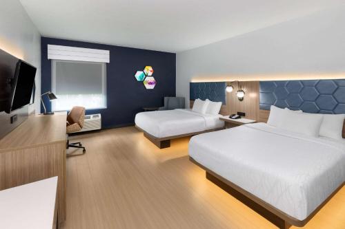 a hotel room with two beds and a television at La Quinta by Wyndham San Antonio Northwest in San Antonio