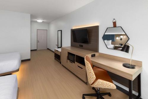 a room with a desk with a television and a chair at La Quinta by Wyndham San Antonio Northwest in San Antonio