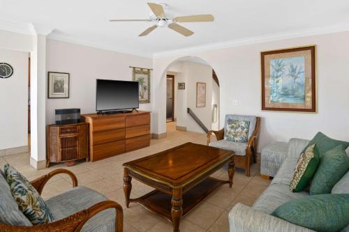 a living room with a couch and a tv at Aston At Poipu Kai in Koloa