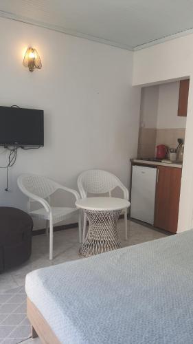 a room with two beds and a table and a kitchen at Vojinovic Apartments in Budva