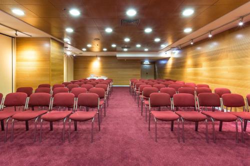 an empty auditorium with red chairs and wooden walls at Radisson Blu Hotel Lisbon in Lisbon