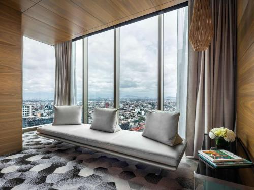 a room with a couch in front of a large window at Sofitel Mexico City Reforma in Mexico City