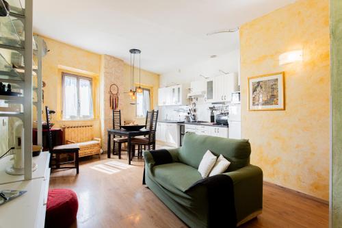 a living room with a green couch and a kitchen at Casa moderna vicino Firenze in Prato