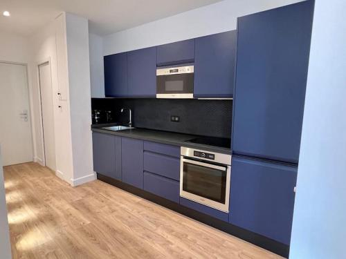 - une cuisine avec des placards bleus et une cuisinière dans l'établissement Bright newly renovated apt with AC, à Paris