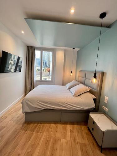 une chambre avec un grand lit et une fenêtre dans l'établissement Bright newly renovated apt with AC, à Paris